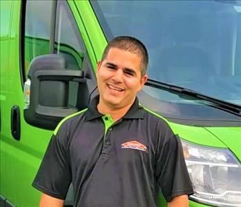 Yoandi in front of a SERVPRO vehicle